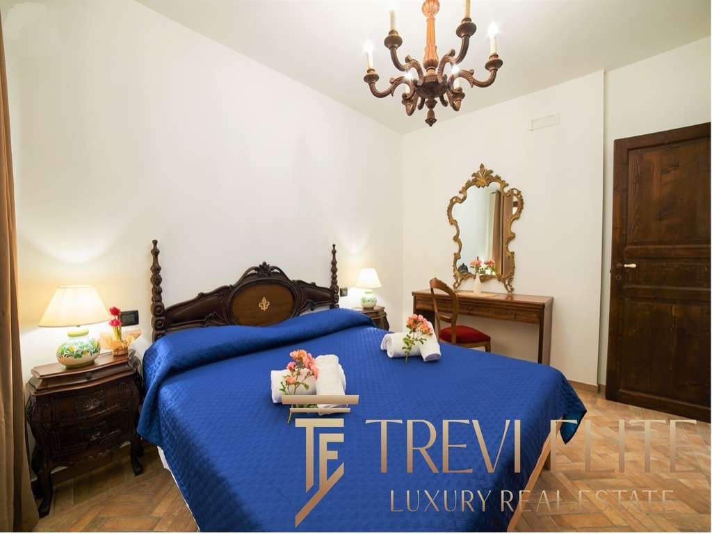 Элегантная спальня в классическом стиле с темной деревянной мебелью и голубым постельным бельем для престижных роскошных апартаментов.