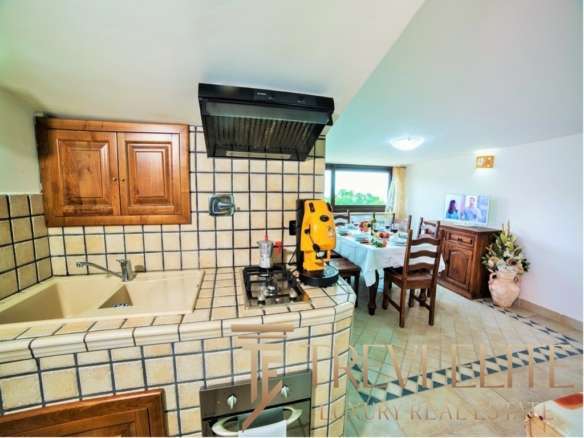 Декоративная кухня с деревянными шкафами и плиткой в стиле кантри, соединяющаяся с обеденной зоной и выходом на террасу с видом на природу. Отличное решение для уютных домашних трапез.