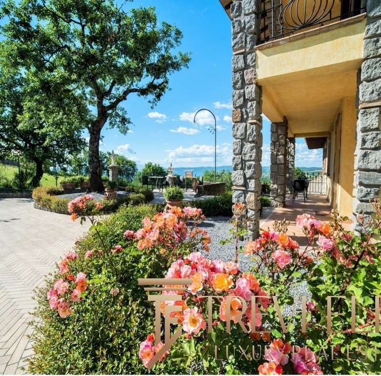 Уютный сад у виллы с яркими розовыми цветами и натуральной каменной отделкой, создающий атмосферу роскоши и спокойствия.