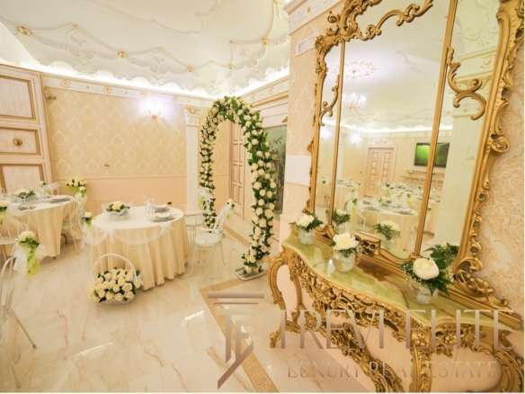 Элегантная зал свадебной церемонии с изысканным декором, цветочными аранжировками и классической мебелью в стиле роскошного особняка.