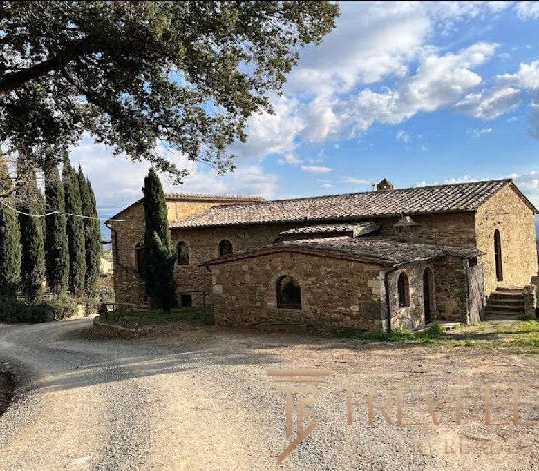 Уединённый каменный дом на итальянской сельской дороге, окружённый живописными деревьями и кедрами, представляет собой уникальную роскошную недвижимость от агентства Треви Элит.