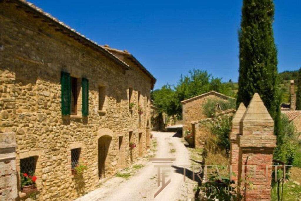 Уютная старинная каменная деревенская улица в итальянской сельской местности с зеленью и цветами.