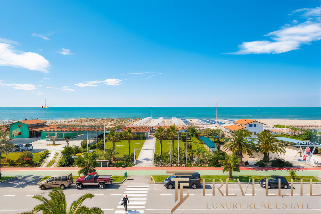 Высококлассный морской пейзаж, вид на пляж и зеленую территорию гостевого комплекса с пальмами под ярким солнцем и голубым небом.