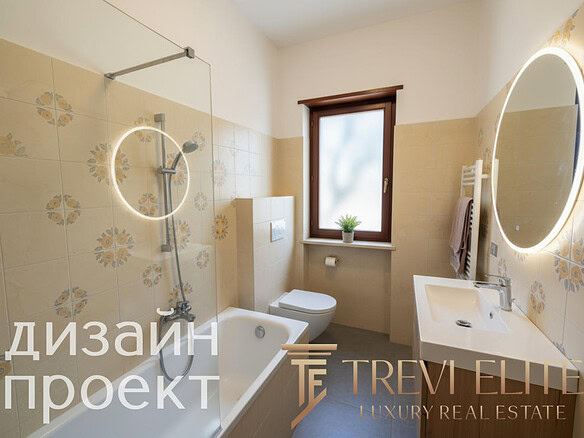 Современная ванная комната с аккуратным дизайном, встроенной раковиной, зеркалом с подсветкой и теплым светлым интерьером, создающим уют и комфорт.