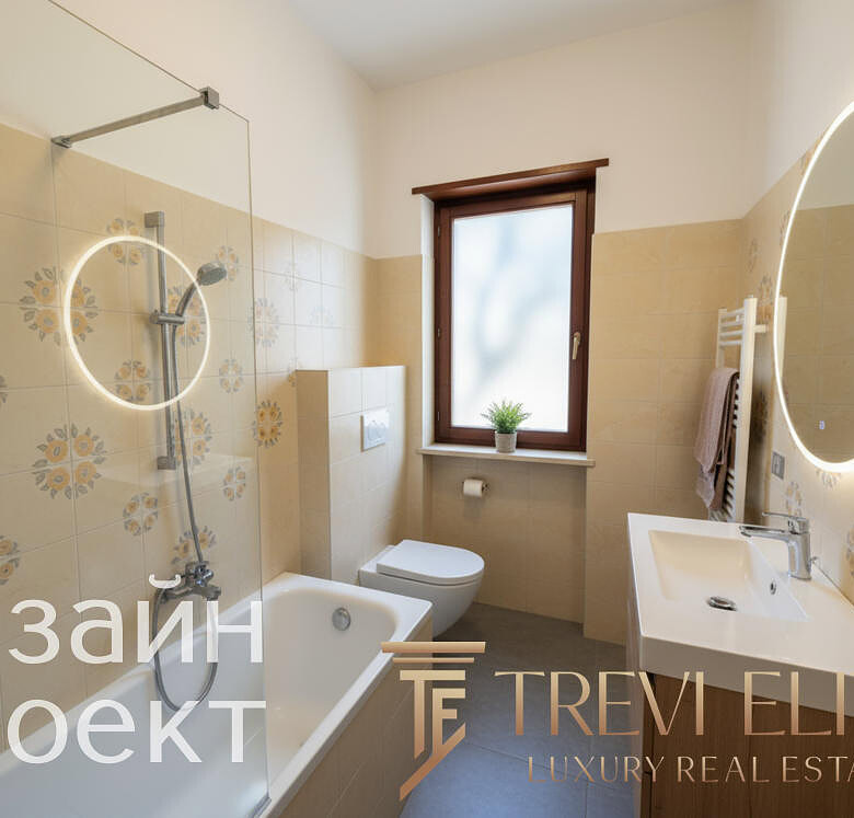 Современная ванная комната с аккуратным дизайном, встроенной раковиной, зеркалом с подсветкой и теплым светлым интерьером, создающим уют и комфорт.