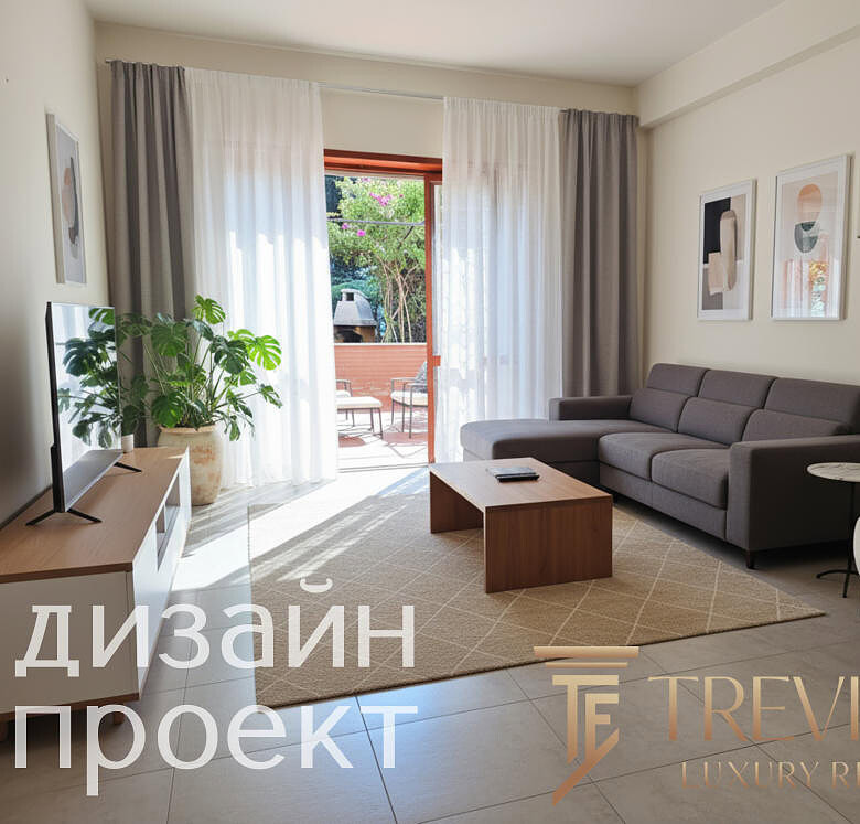 Современная гостиная с мягким серым диваном, декоративными картинами, светлыми шторами и частным балконом на заднем плане, создающая уютную атмосферу для комфортного проживания.