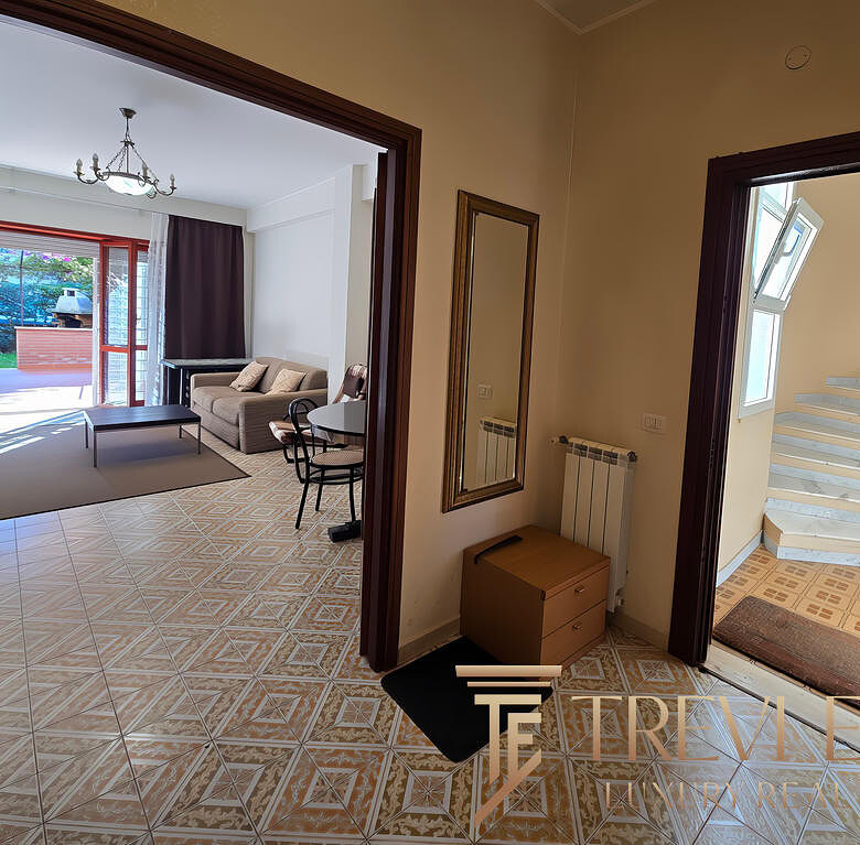 Вход в современную квартиру с ярким интерьером, светлым залом и лестницей, ведущей на верхний этаж, на фоне окна с естественным освещением, дизайн квартиры для комфортного проживания.