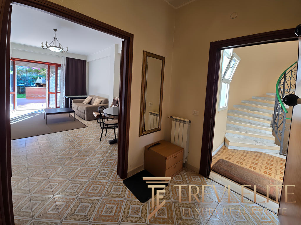 Вход в современную квартиру с ярким интерьером, светлым залом и лестницей, ведущей на верхний этаж, на фоне окна с естественным освещением, дизайн квартиры для комфортного проживания.