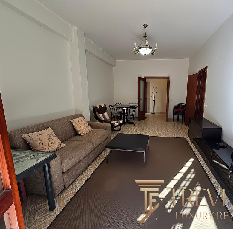 Современная гостиная с уютным диваном, телевизором и просторной зоной для отдыха и развлечений, светлым интерьером и стильным декором, идеальная для комфортного проживания.