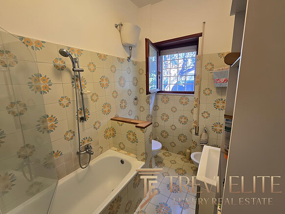 Высококачественная ванная комната с мозаичной плиткой в стиле 70-х годов, ванной с душевой кабиной, окном с видом на сад, идеально подходит для уютных домашних моментов.