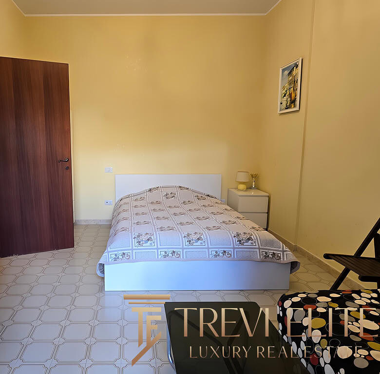 Современная спальня в роскошной квартире, минималистский дизайн, светлые стены, удобная кровать, мебель из светлого дерева, приятная атмосфера, идеально подходит для отдыха.