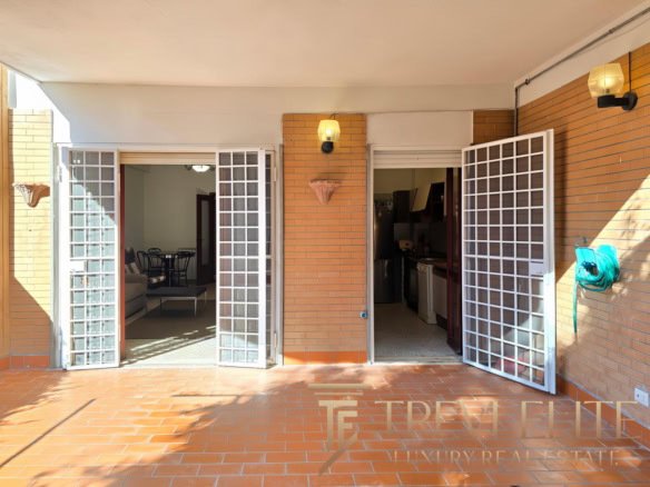 Высококачественное изображение уютного балкона с видами на внутреннюю часть квартиры, открывающегося через белые сетчатые двери, с освещением и обустроенной зоной отдыха.