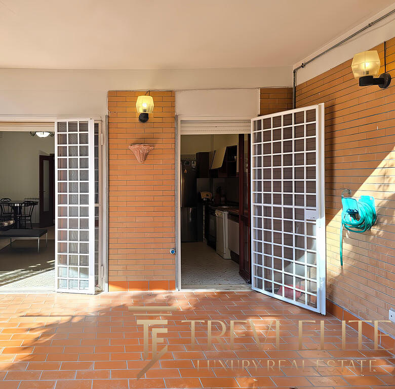 Высококачественное изображение уютного балкона с видами на внутреннюю часть квартиры, открывающегося через белые сетчатые двери, с освещением и обустроенной зоной отдыха.