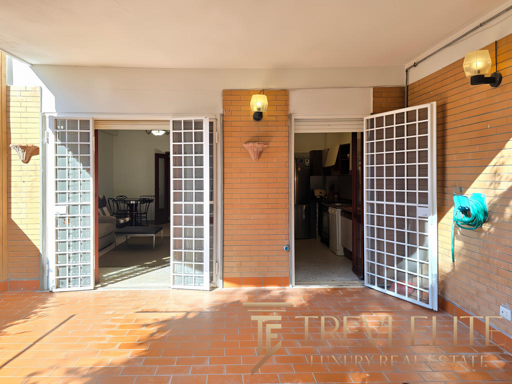 Высококачественное изображение уютного балкона с видами на внутреннюю часть квартиры, открывающегося через белые сетчатые двери, с освещением и обустроенной зоной отдыха.