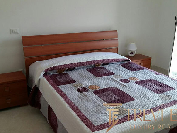 Современная спальня с деревянной мебелью и выходом на балкон, оформление в нейтральных тонах, уютное и просторное помещение для комфортного отдыха и проживания.