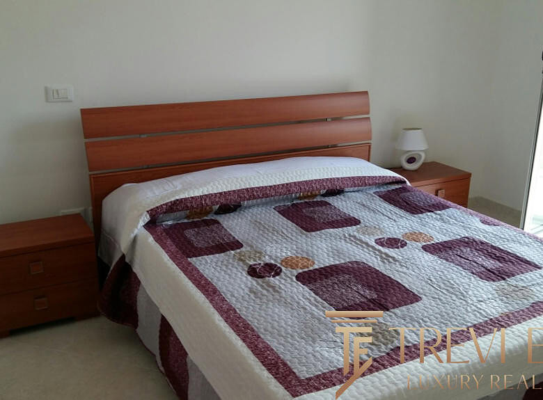 Современная спальня с деревянной мебелью и выходом на балкон, оформление в нейтральных тонах, уютное и просторное помещение для комфортного отдыха и проживания.