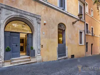Ochre travertine palazzo facade with arched blue entrance, Rome