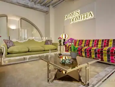 Luxury salon with lime-green sofa, colorful armchair, exposed beams, Rome
