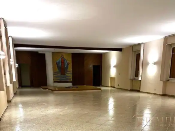 Просторный холл приема с полированным полом из травертина и современным освещением