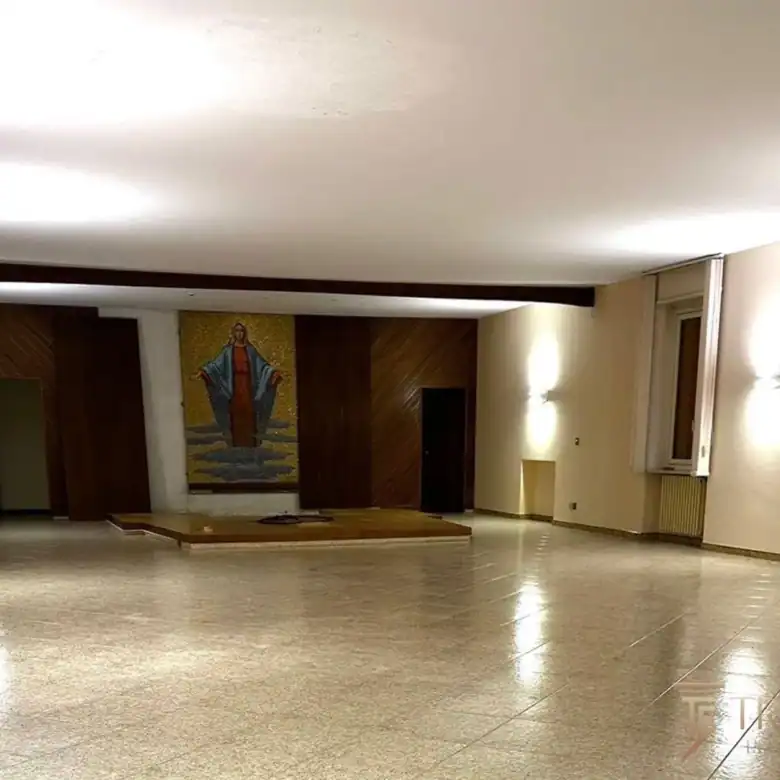 Просторный холл приема с полированным полом из травертина и современным освещением