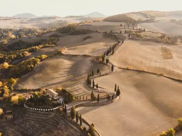 Rolling hills and farmhouses of the Val d'Orcia in Tuscany.